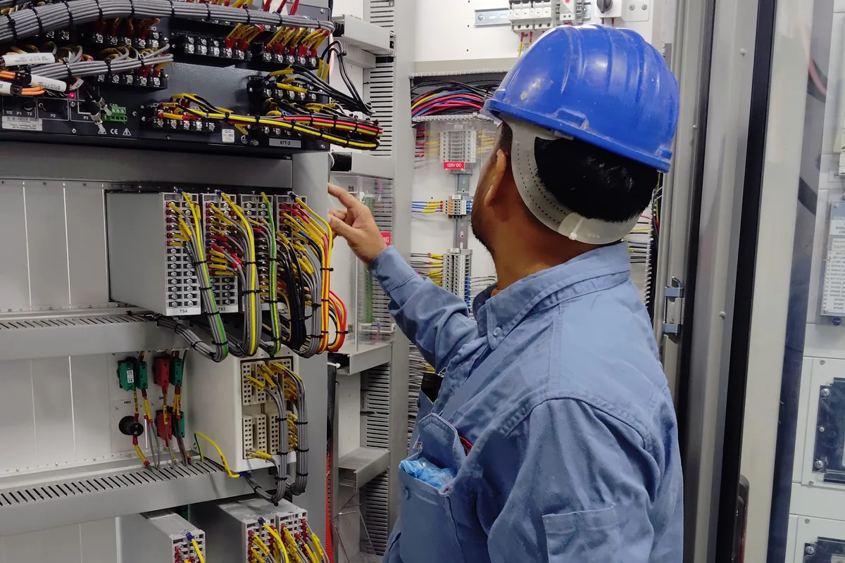Électricien intervenant sur une armoire électrique aux câbles repérés