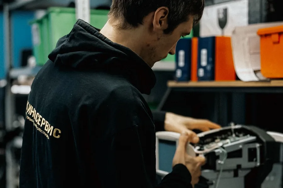 Technicien M2R réparant un copieur professionnel en atelier